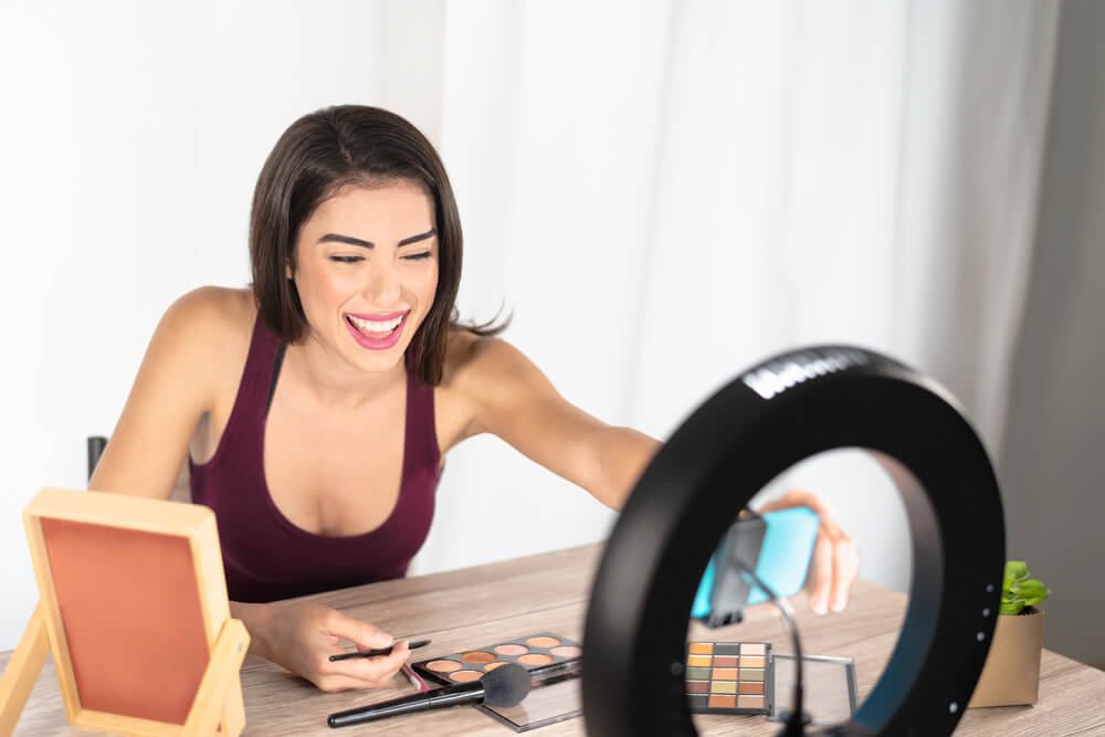 Young female blogger doing makeup tutorial