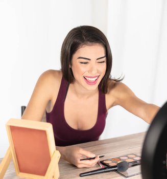 Young female blogger doing makeup tutorial