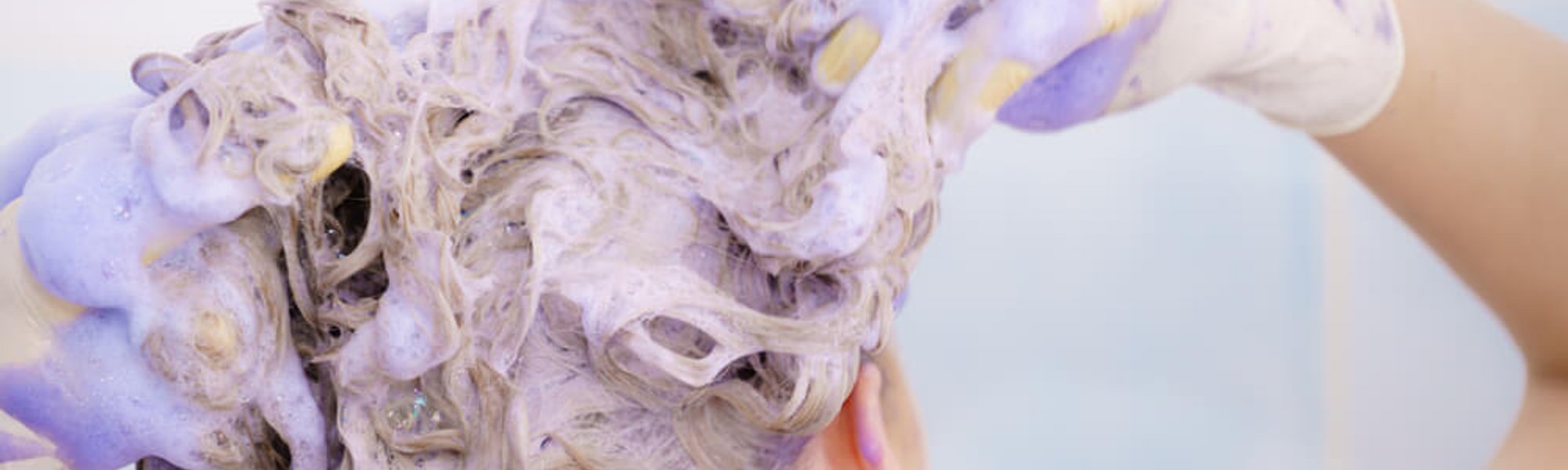 Woman applying coloring shampoo on her hair